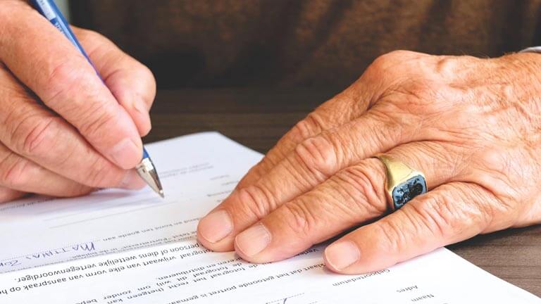 Image of man signing a South Florida Estate Planning Document with Estate Planning Attorney Boca Raton, ASR Law Firm. 