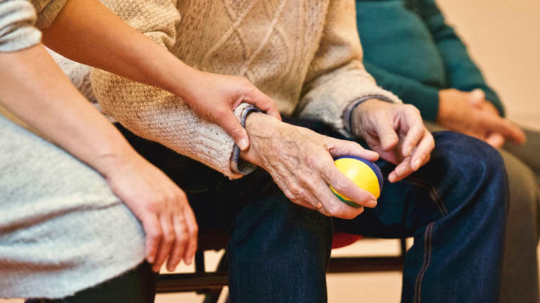 Image of a caregiver helping an elderly man with information related to Florida Living Wills & healthcare directives. 