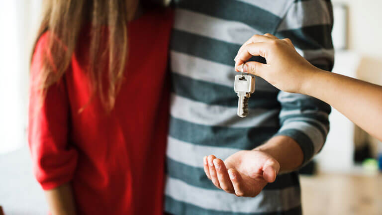 An image of a couple receiving the keys to their new apartment that illustrates the comprehensive real estate lease contract solutions with Boca Raton Real Estate Attorney, ASR Law Firm.