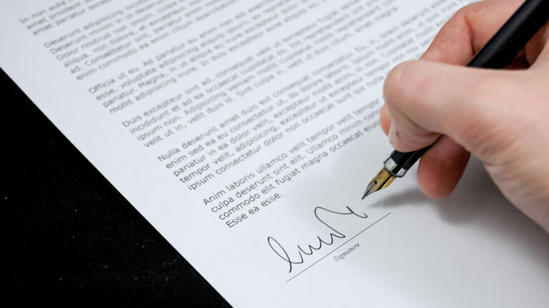 An image of a person signing a real estate contract that illustrates the comprehensive real estate conveyance and Boca Raton Real Estate Attorney solutions at ASR Law Firm.