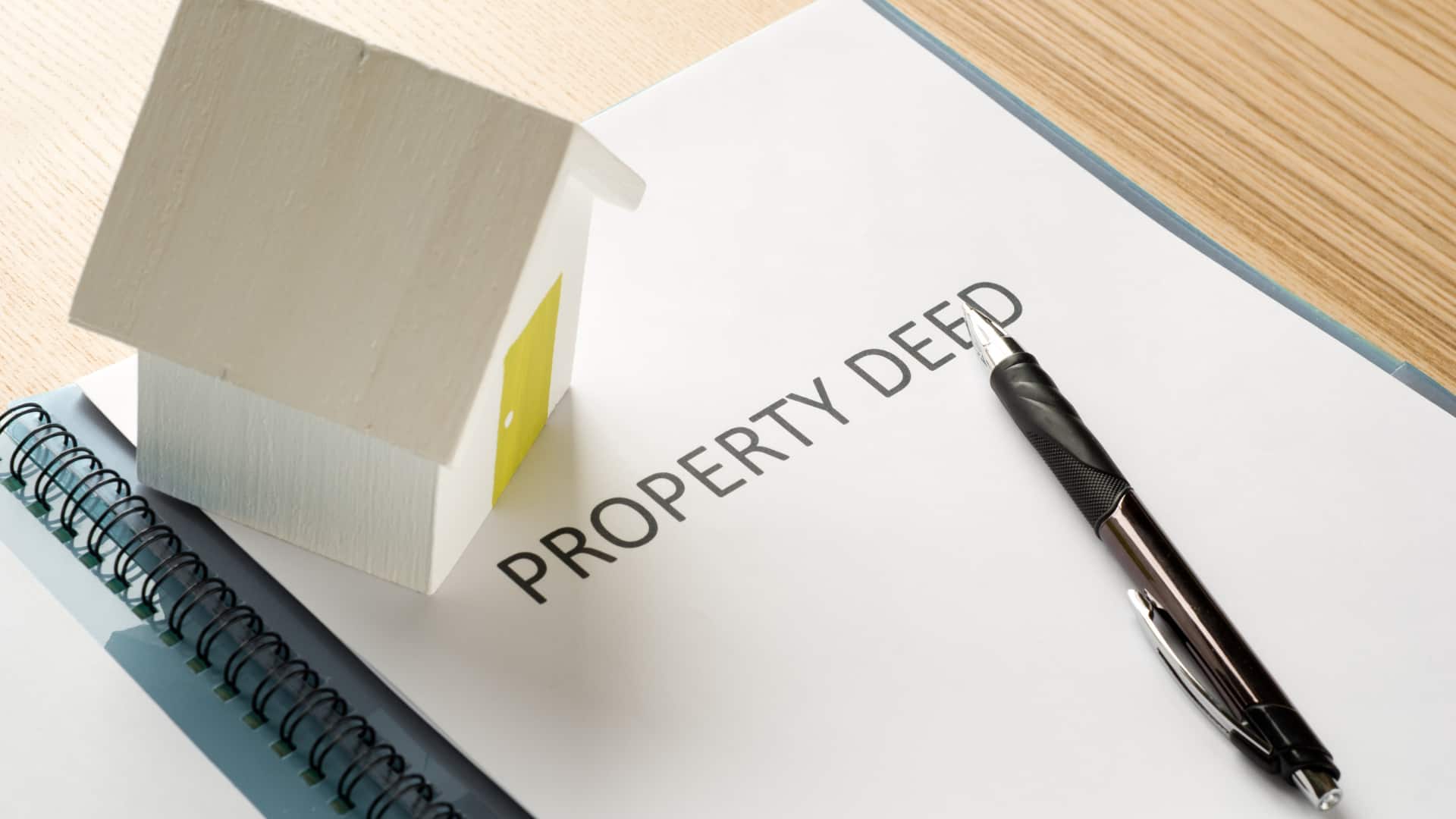 An image of a property model on top of a property deed document.