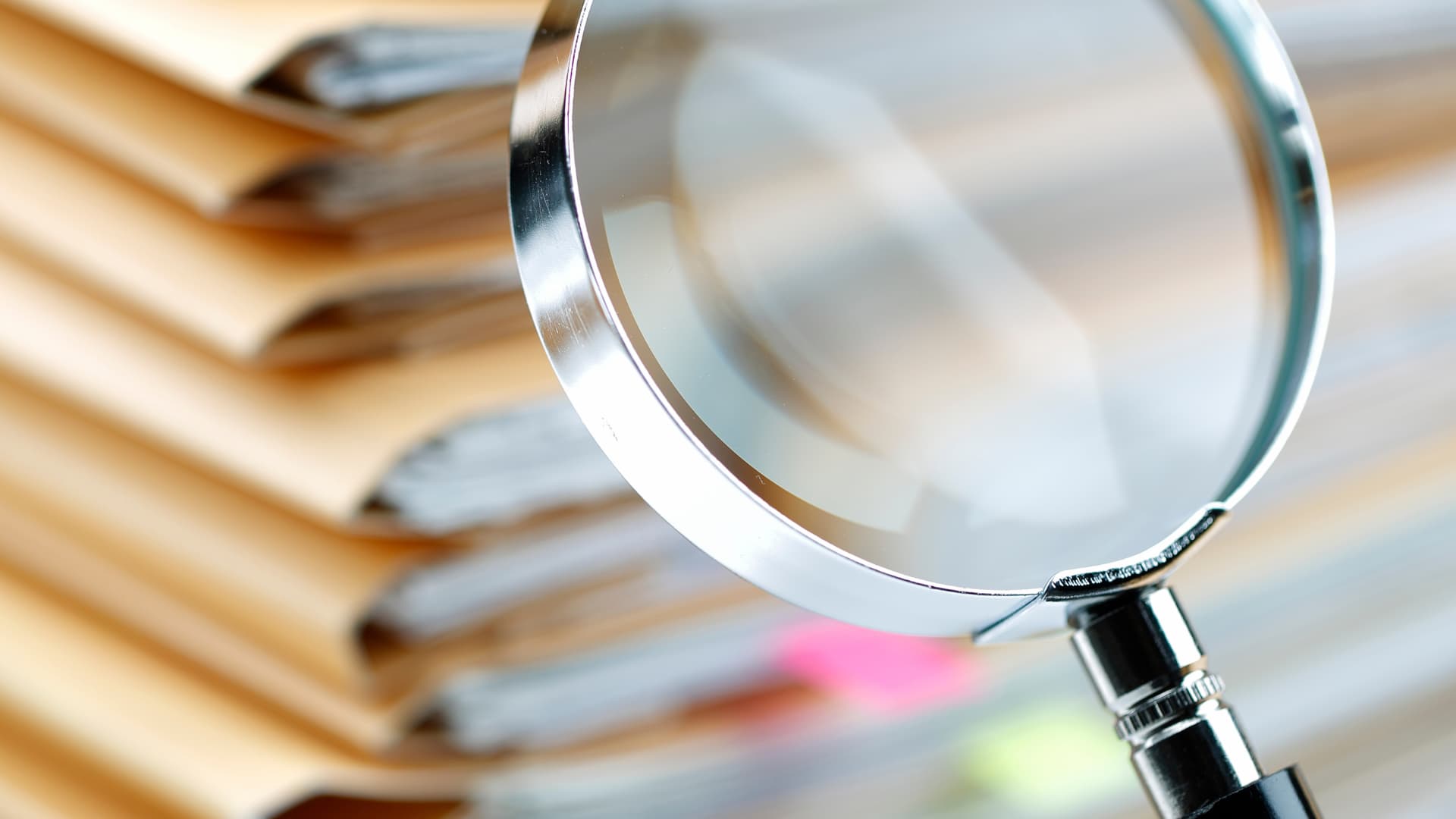 An image of a magnifying glass on top of documents for Florida Annual Reporting