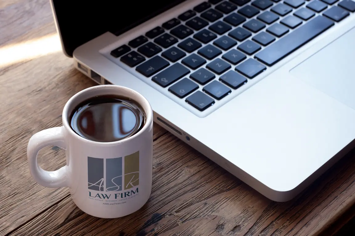 An image of an ASR Law Firm coffee cup next to a computer after a virtual consultation.