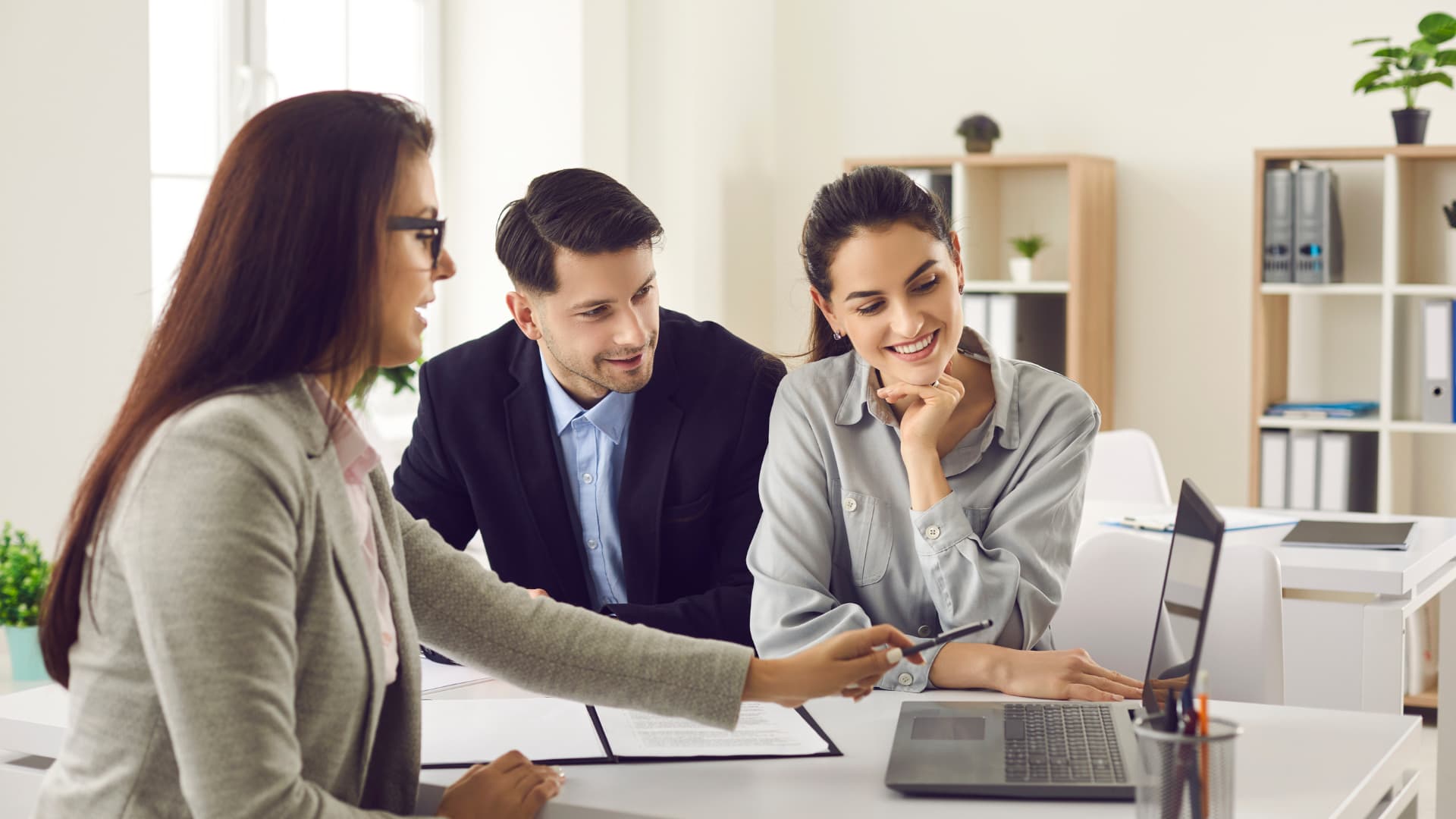 An image of an estate planning attorney meeting with a couple about their trademarks. 