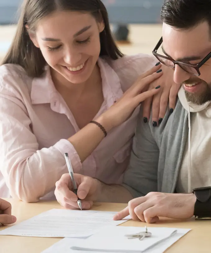 An image of a happy couple meeting with their attorney. 