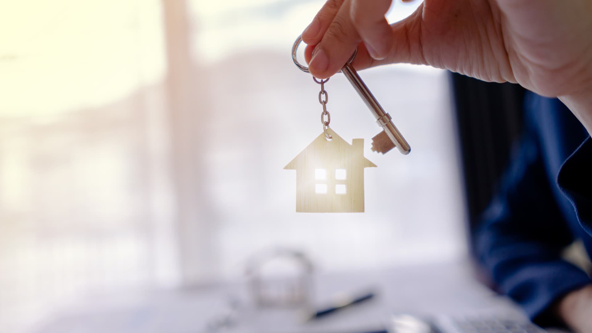 An image of a person holding up a home key.