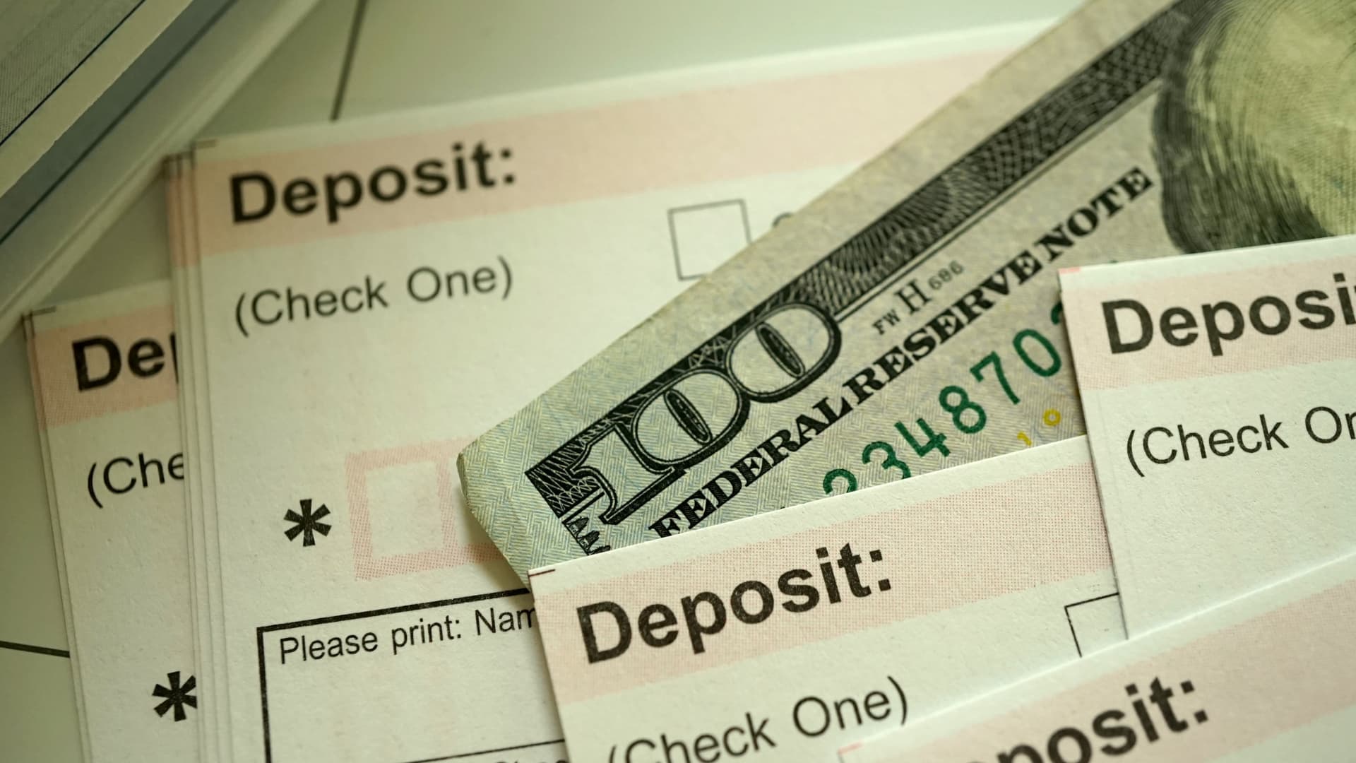 An image of deposit slips and money illustrating how a Revocable Living Trust can be funded. 