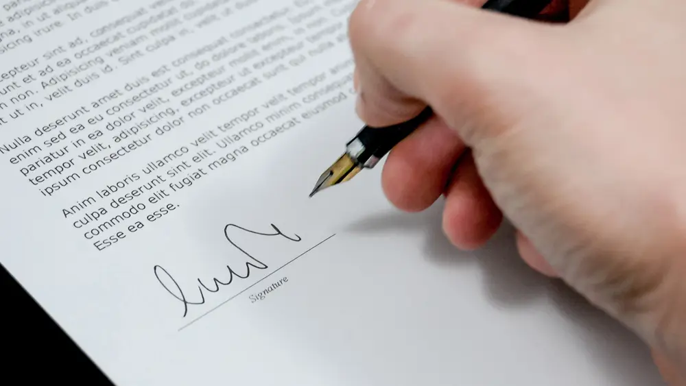 An image of a person signing a legal document.
