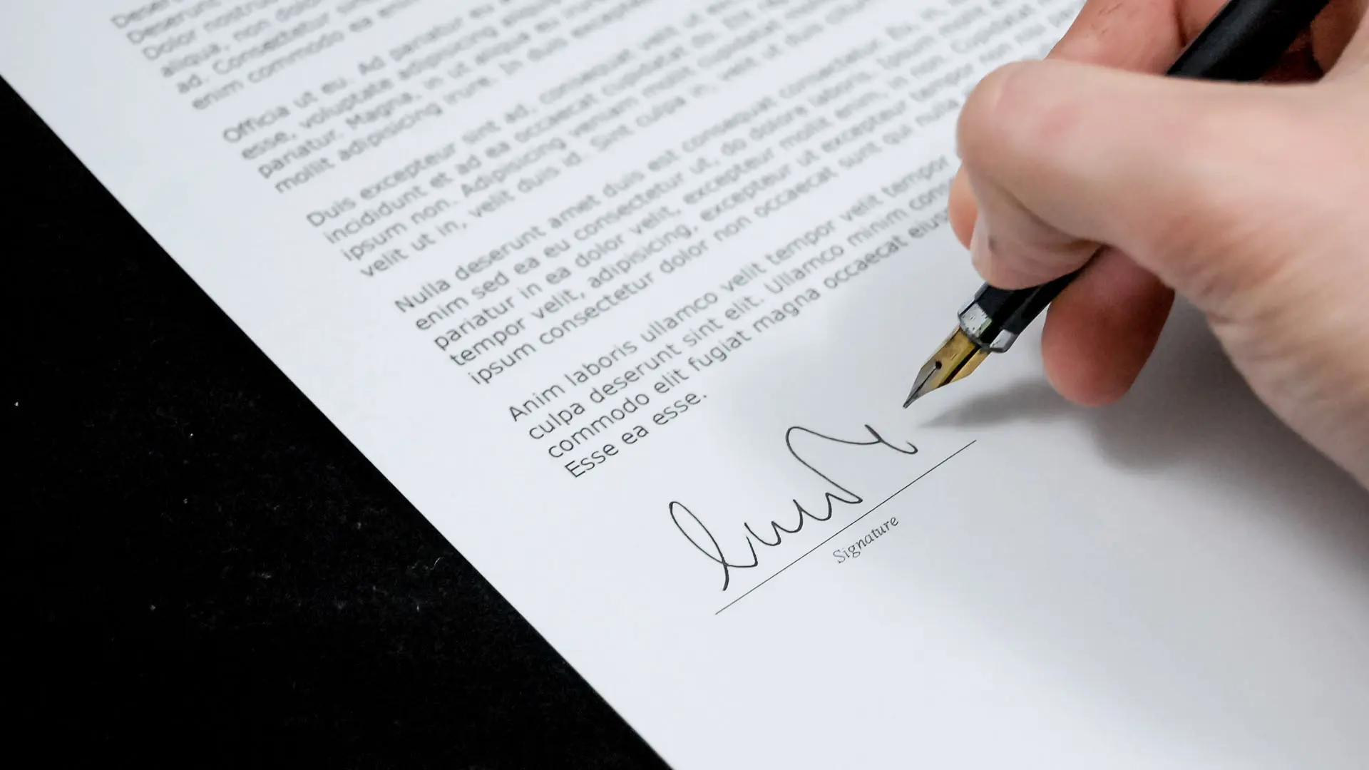 An image of a person signing a legal document. 