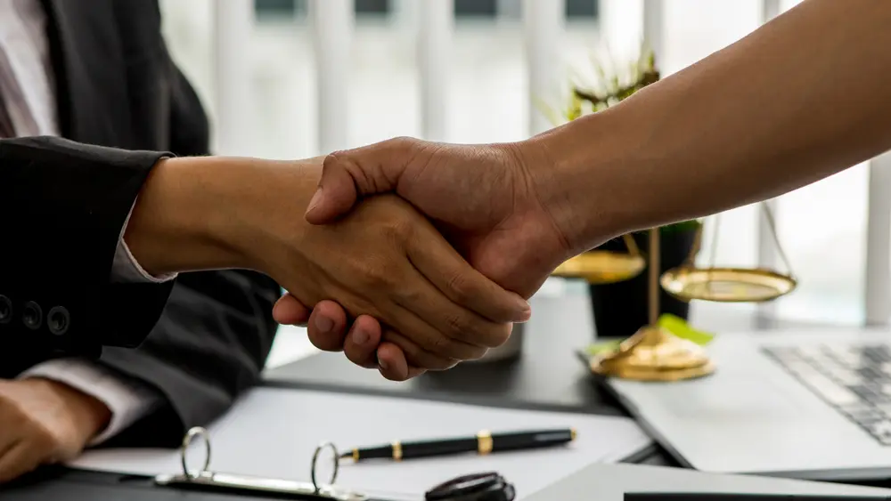An image of attorney and client shaking hands after successful matters.