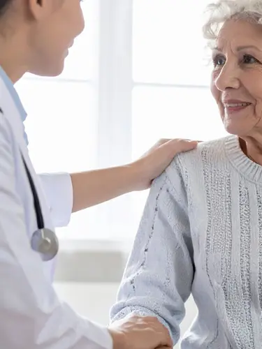 An image of an elderly patient meeting with a doctor. 