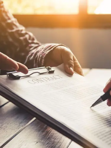 An image of a business owner signing a business contract after consulting with a Florida Business Attorney. 