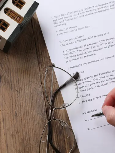 An image of a person signing a document to protect their family from probate.