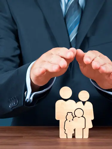 An image of an attorney with their hands over a family model showing how a will and trsut can protect your family. 
