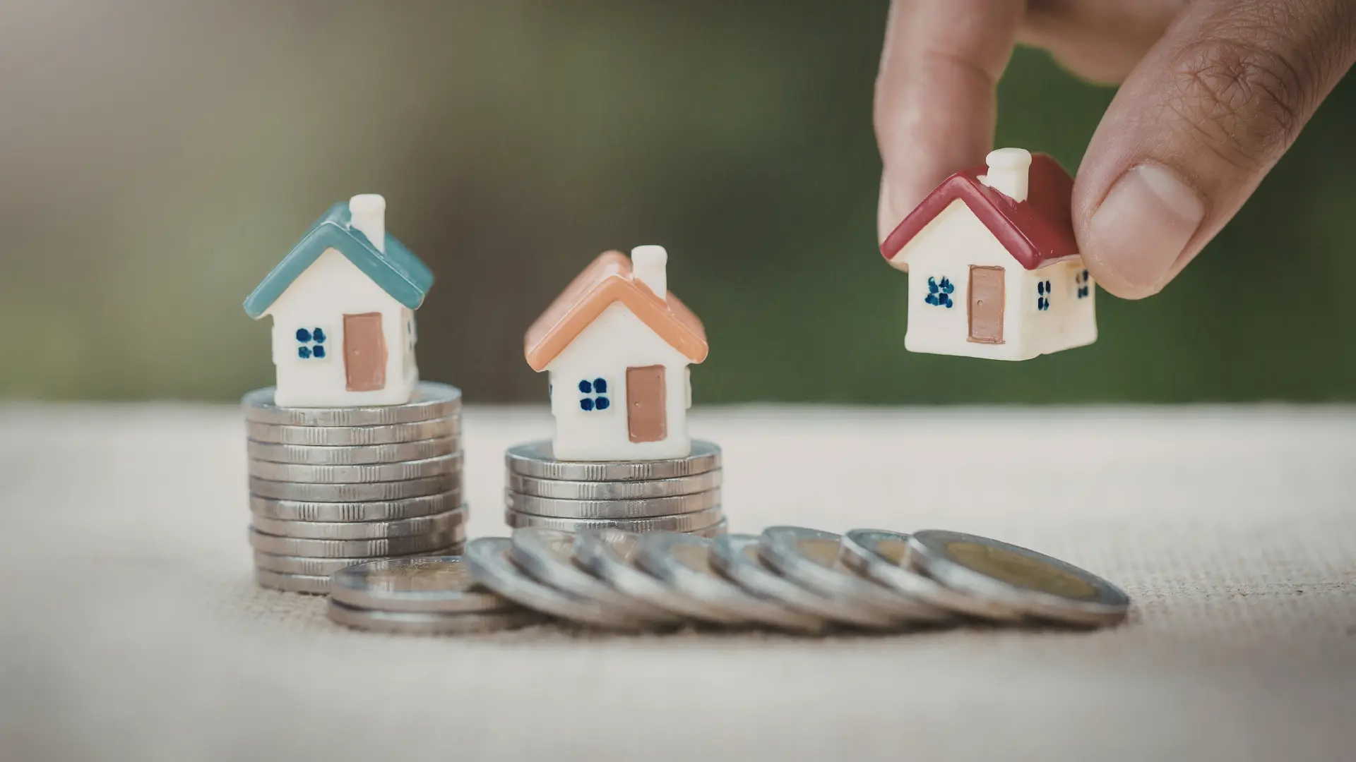 An image of home models on top of coins showing property investment. 